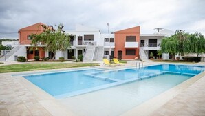 Un bâtiment moderne doté d’une piscine, d’un espace extérieur aménagé et d’un escalier menant aux étages supérieurs.