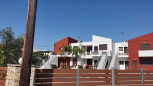 Un bâtiment moderne aux couleurs rouge et blanche, doté d’un escalier menant à un balcon.