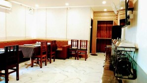 Un comedor con asientos tipo cabina, una barra con fregadero y un armario de madera.