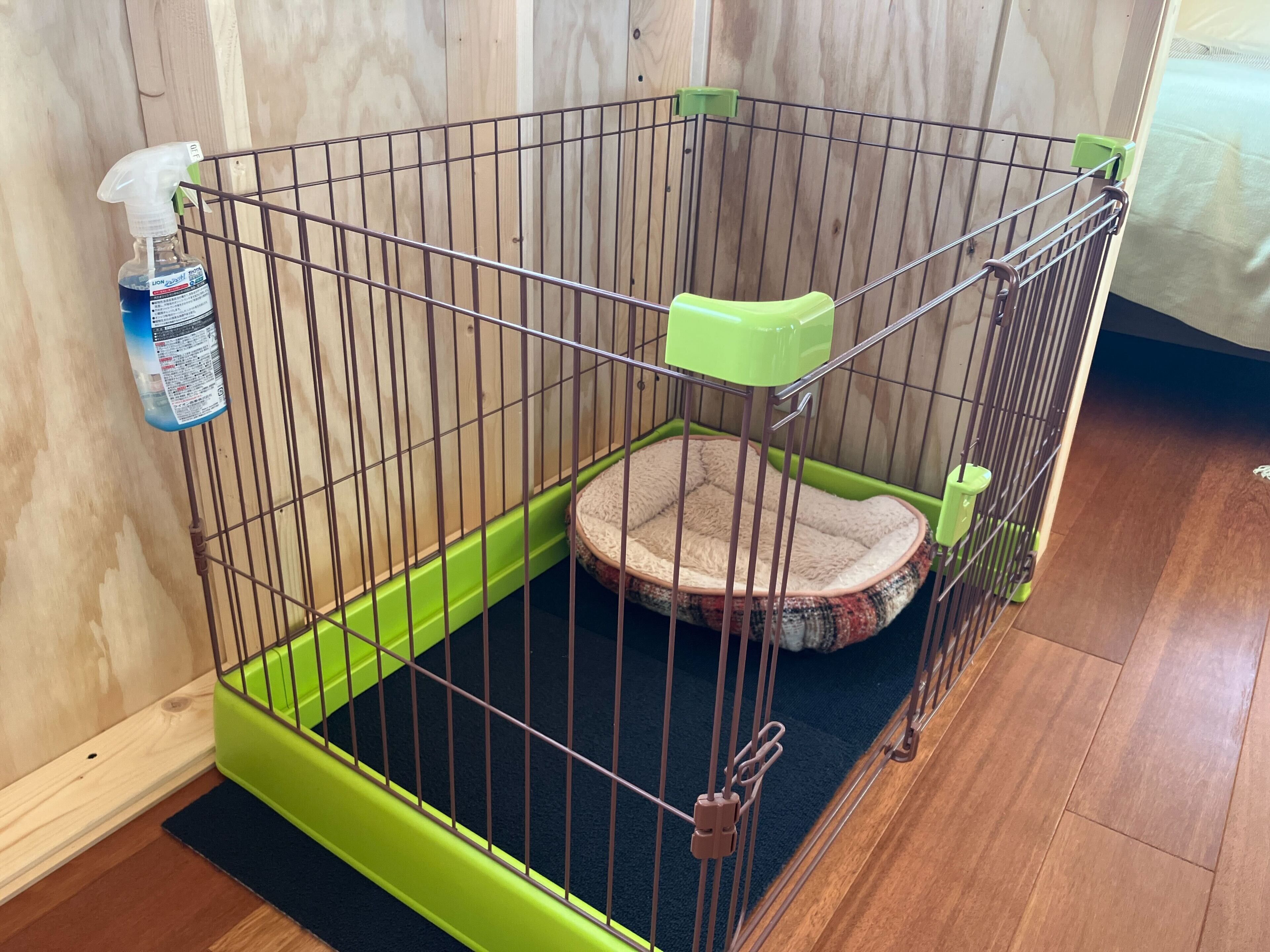 Una jaula para mascotas con piso verde y una cama suave en su interior.