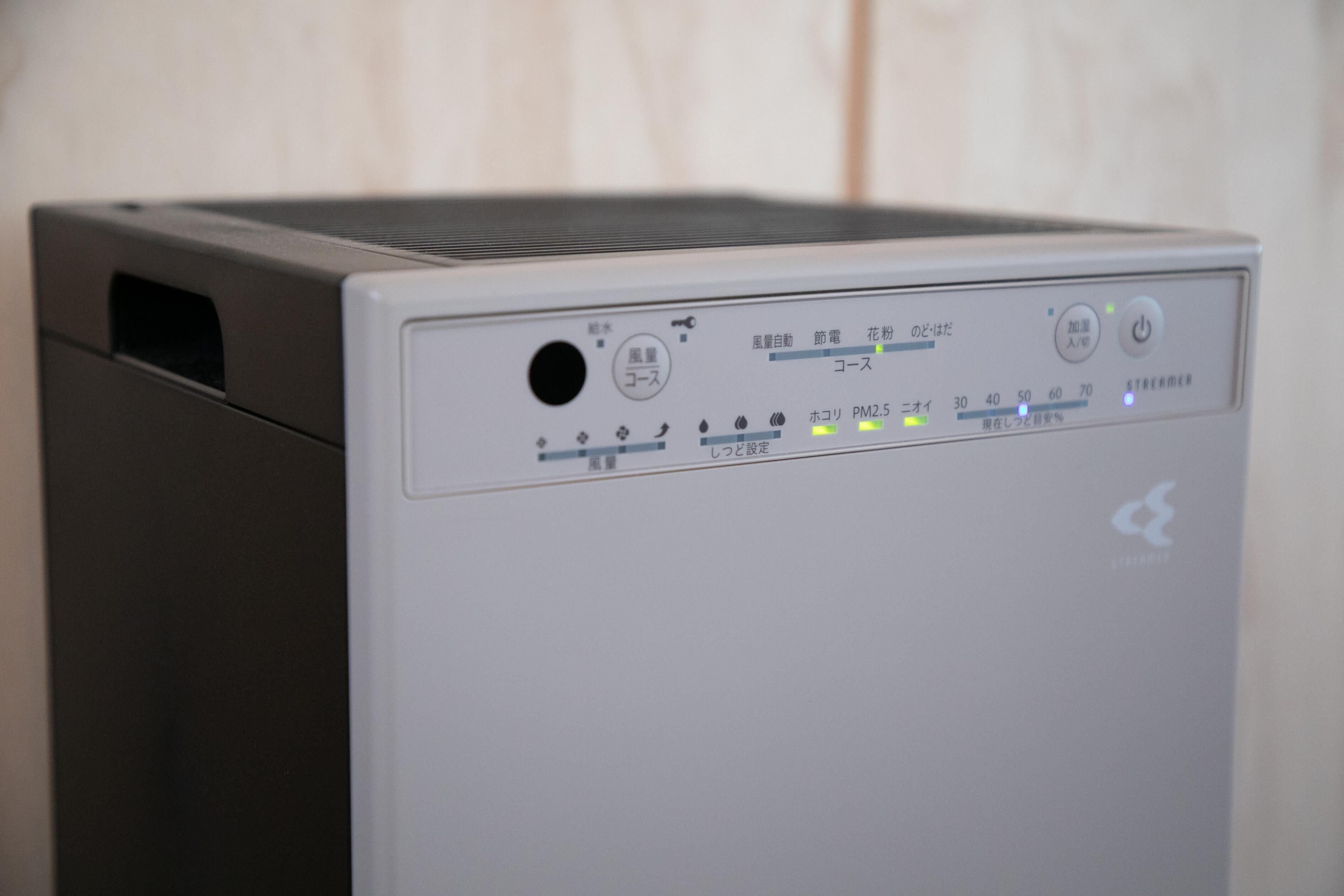 A compact, modern air purifier with a control panel featuring multiple settings and indicators.