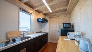 Una cucina moderna con mobili in legno, forno a microonde integrato e un tostapane.