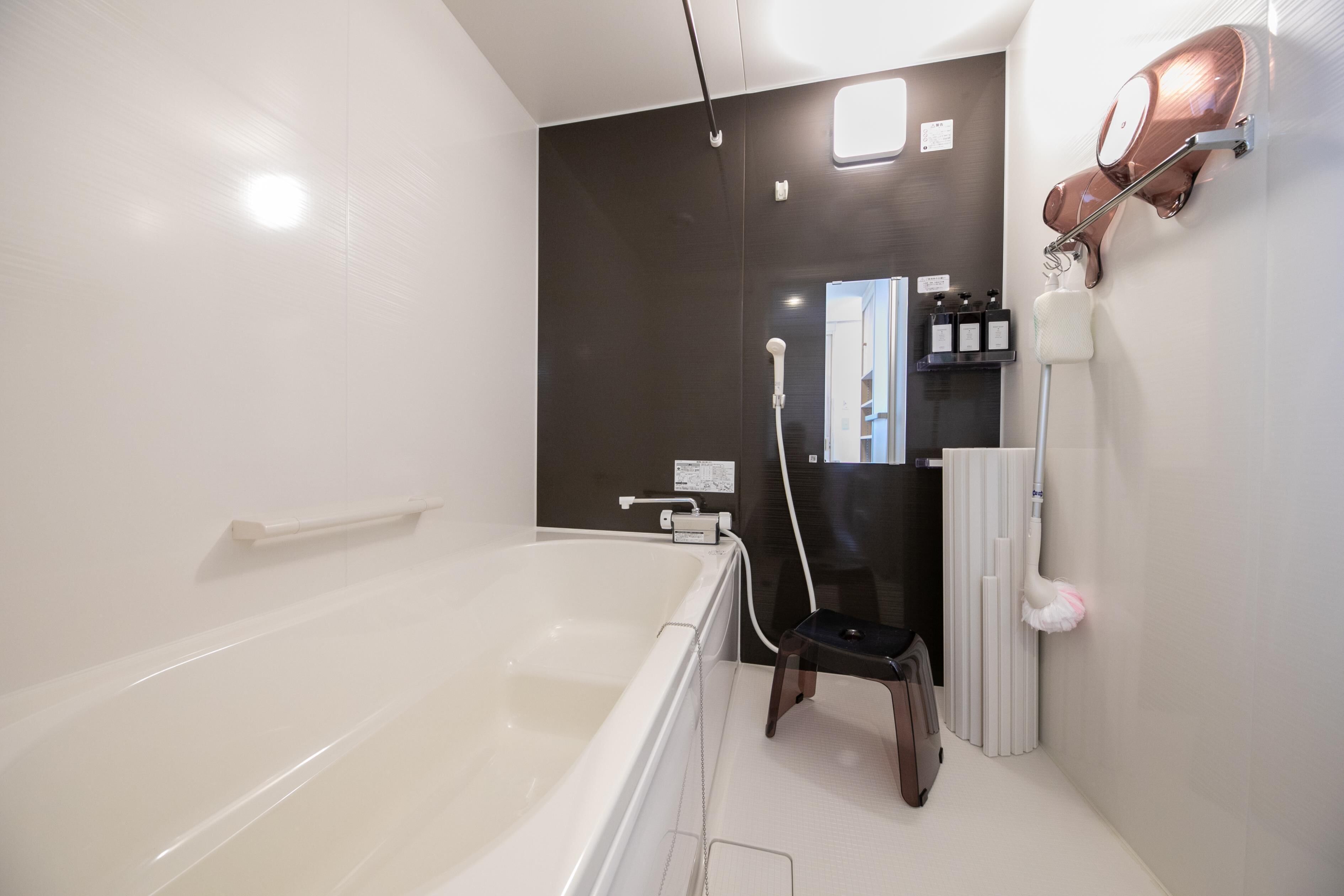 Un baño moderno con bañera, ducha y tocador con espejo.