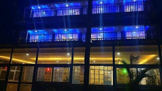 A multi-story building with large windows and balconies. - THE BASE HOTEL (Mbooni)