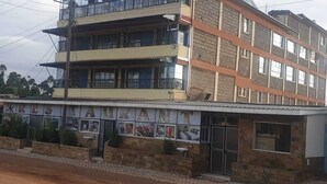A multi-story building with a restaurant on the ground floor. - THE BASE HOTEL (Mbooni)