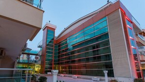 A modern building with large glass windows and a red-lit facade.