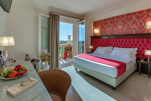 Une chambre d’hôtel avec un lit, une table à manger avec des fruits, une chaise et une vue sur l’extérieur.