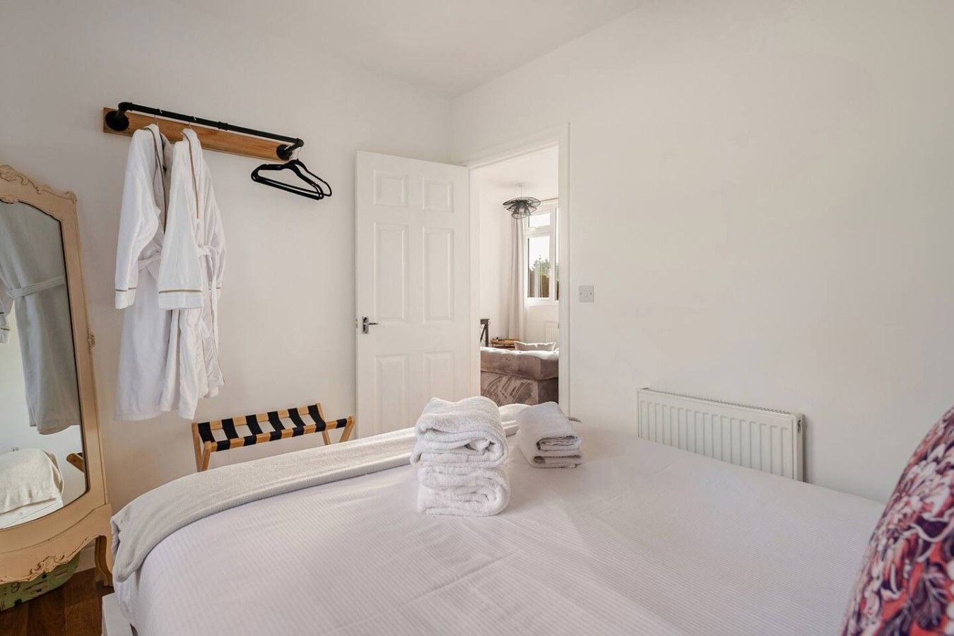 Habitación de hotel con cama, una silla, un espejo y una puerta que da a un baño.