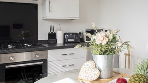 Eine Küche mit Herd, Toaster und einer Blumenvase auf der Arbeitsplatte.