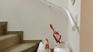 Un escalier orné d’un coq en céramique blanche et d’un pichet en céramique blanche, tous deux placés sur les marches.