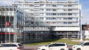 En modern byggnad med en glasfasad och flera våningar.