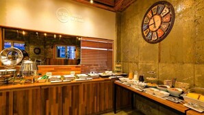 A buffet setup with various food items and a clock on the wall. - The Stay Series (Daegu)