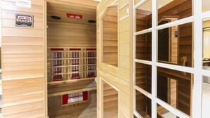 A sauna with wooden walls, a control panel, and multiple benches. - The Stay Series (Daegu)
