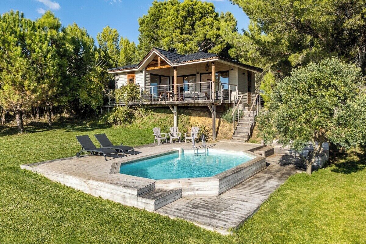 A two-story house with a deck and a swimming pool.