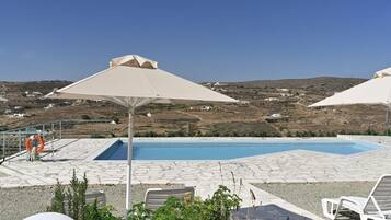 Una piscina al aire libre de temporada, sombrillas