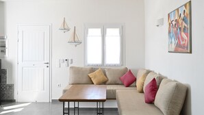 Una sala de estar moderna con un sofá color beige, una mesa de centro de madera y un ventilador de techo.
