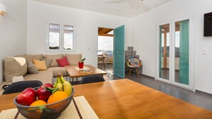 Una sala de estar moderna con una mesa de comedor de madera, un sofá y un ventilador de techo.