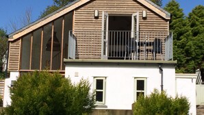 A modern house with a sloped roof, large windows, and a balcony. - Luxury child and baby friendly rural retreat. Close to Porthleven and St Ives (Helston)
