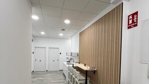 Una cocina moderna con un panel de madera en la pared, una encimera larga y un extintor de incendios colgado.