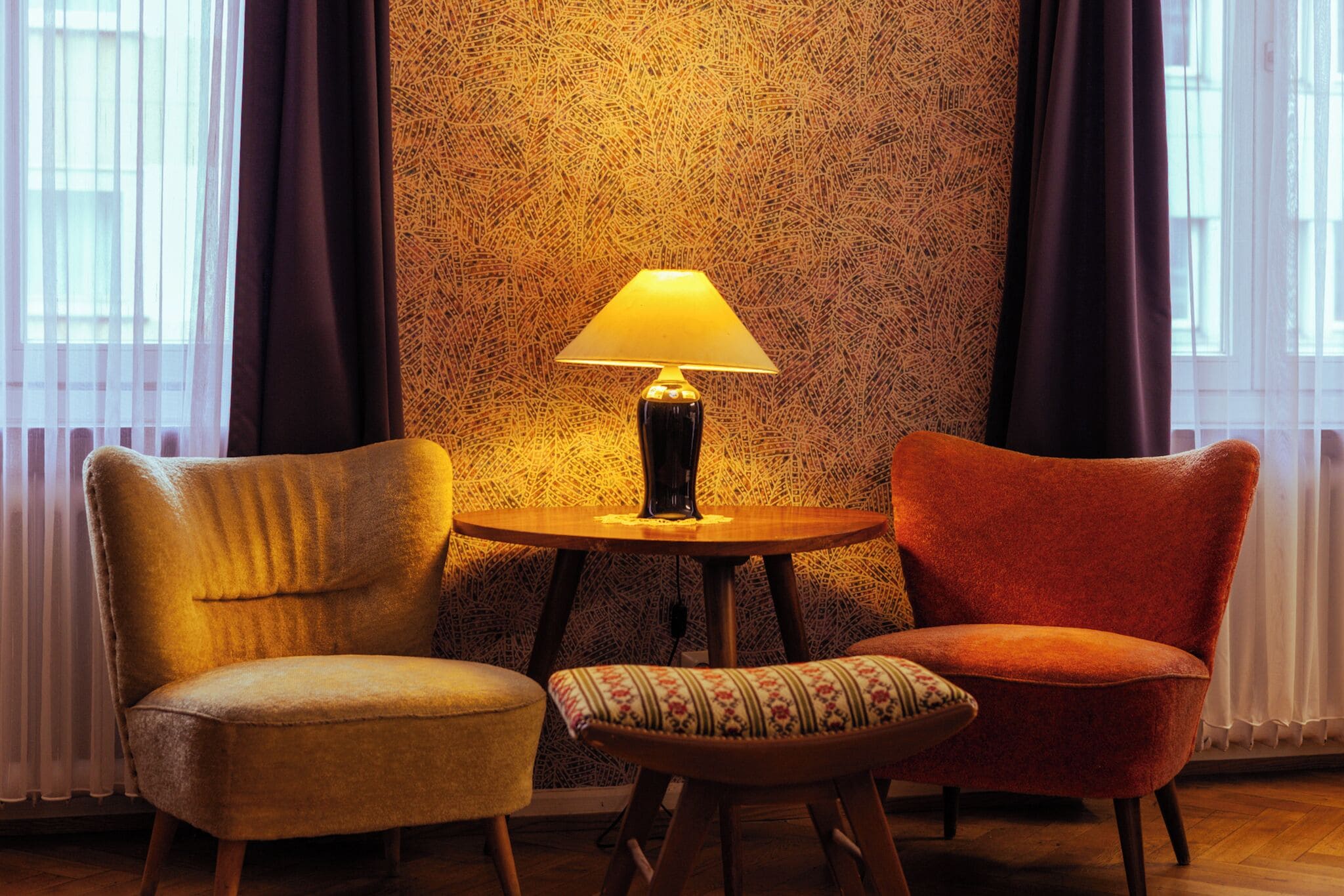 A room with two armchairs and a small table with a lamp.