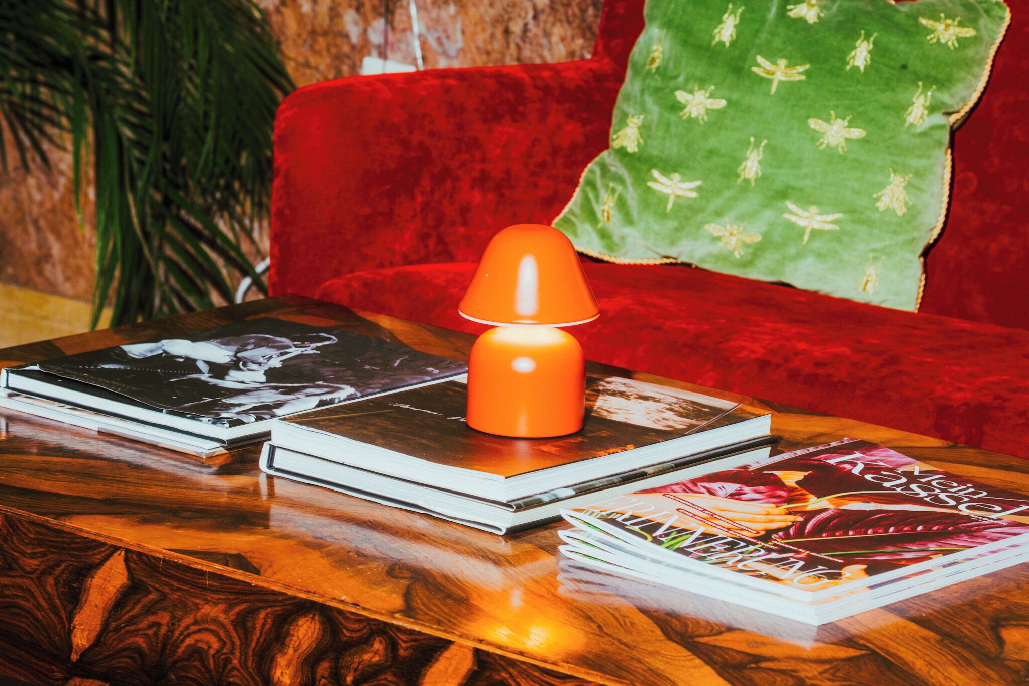 Una mesa de centro de madera con libros y una lámpara de mesa.