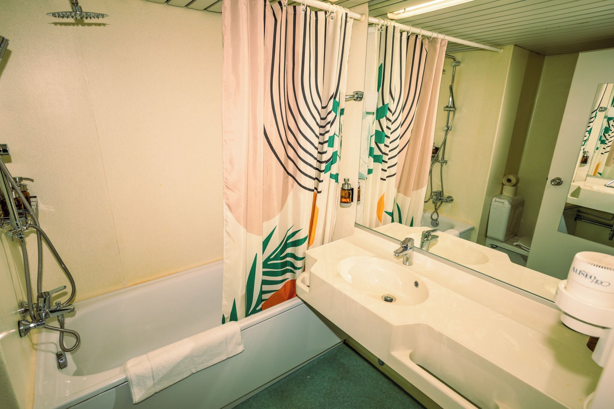 Un baño con bañera, lavabo, espejo y ducha.