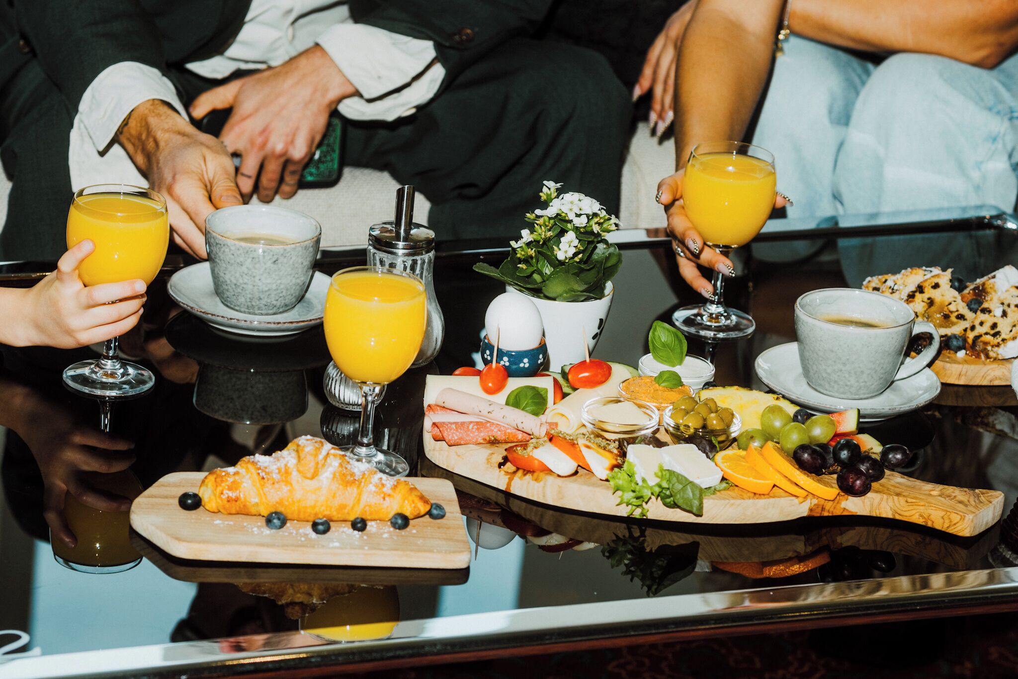 Un desayuno con una variedad de alimentos y bebidas sobre una mesa de vidrio.