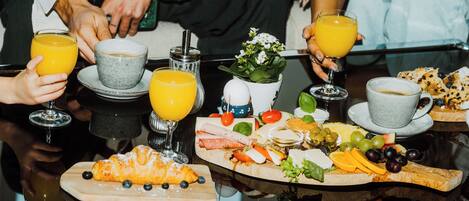 A breakfast setting with a variety of foods and drinks on a glass table.