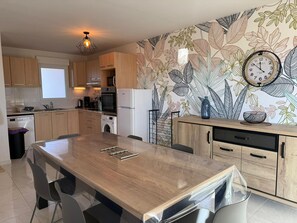 A modern kitchen with wooden cabinets, a central island, a microwave, oven, and a refrigerator.