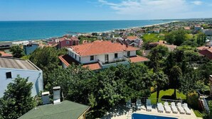 Zona residencial costeira com casas, piscina e vista para o mar.