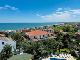 Una zona residencial costera con casas, una piscina y vistas al mar.