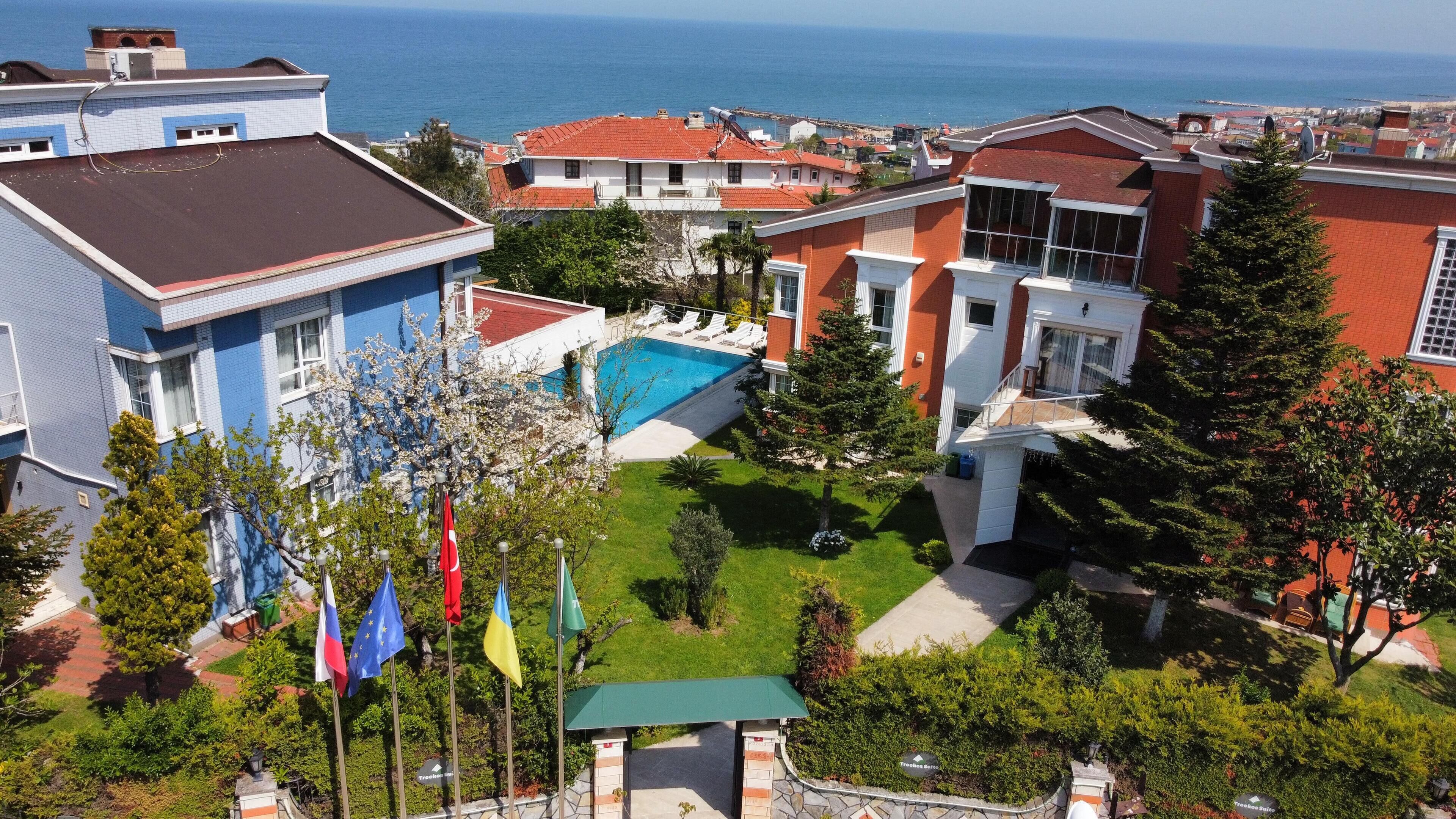 Área residencial com piscina, várias bandeiras e vista para o mar.