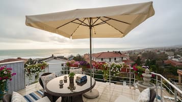 Familierom, sjøutsikt | Spiseområde på rommet