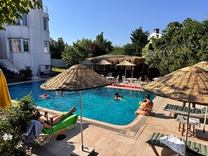 Een buitenzwembad, parasols voor strand/zwembad