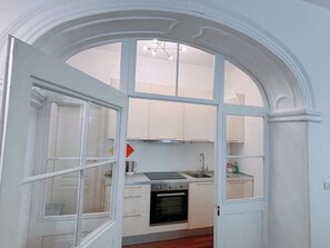 A kitchen with white cabinets, a stove, and a sink.