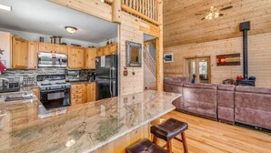 A spacious kitchen with wooden cabinets, a granite countertop, and a built-in oven.