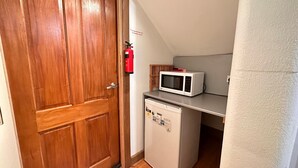 Une petite cuisine équipée d’un four à micro-ondes et d’un petit réfrigérateur.