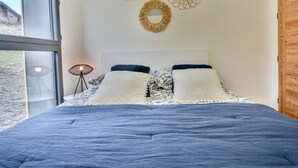 A bedroom with a large bed, a window, and wall decor.
