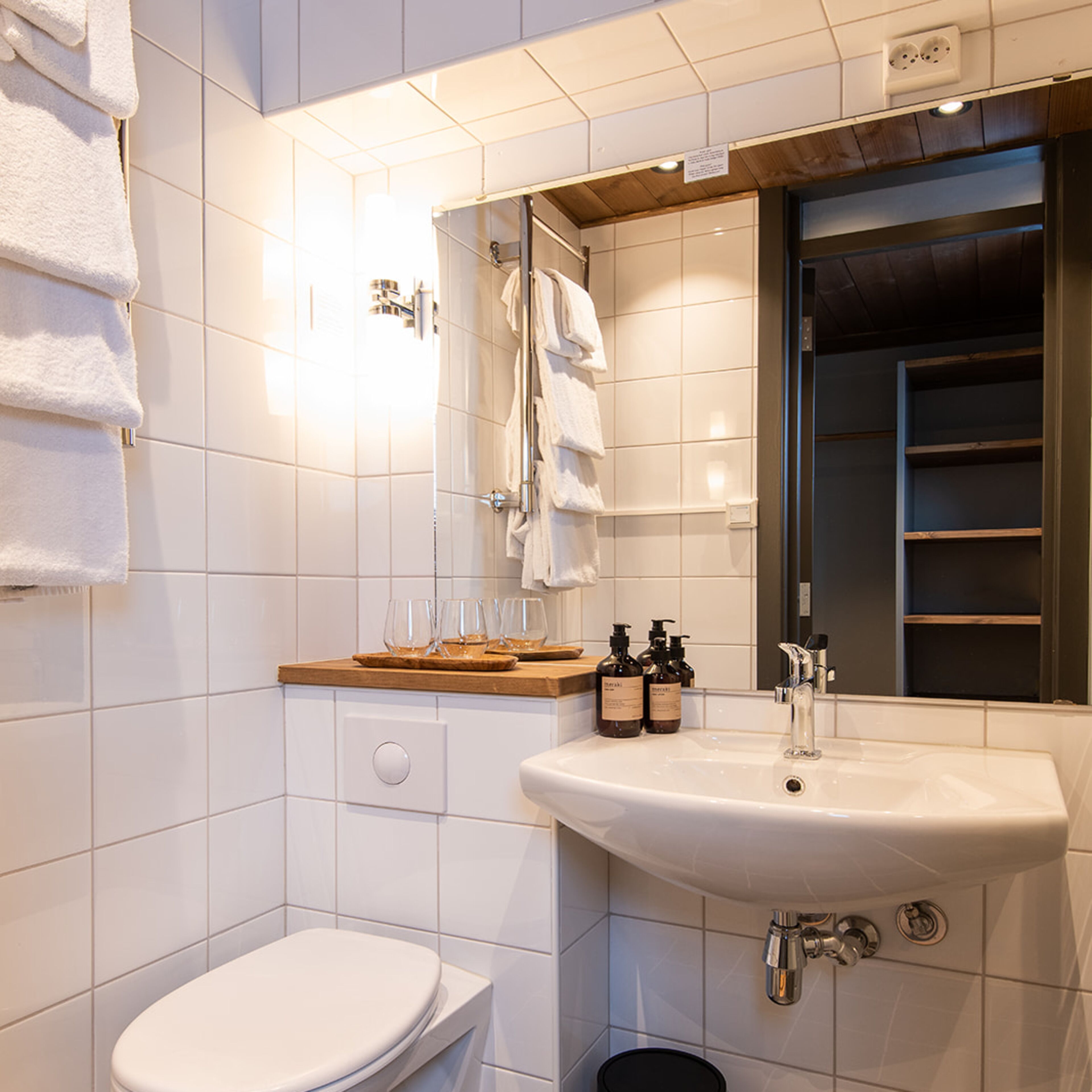 A modern bathroom with a white toilet, a sink with a mirror above it, and a towel rack.