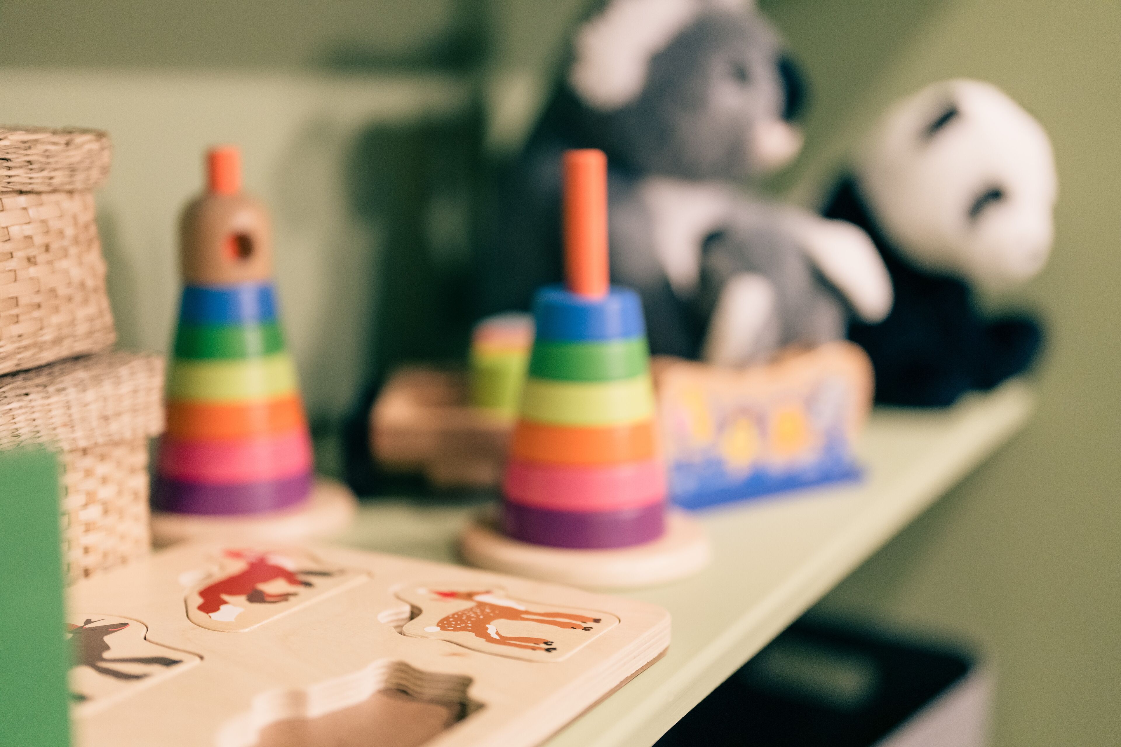 A shelf with wooden toys and a panda figurine.