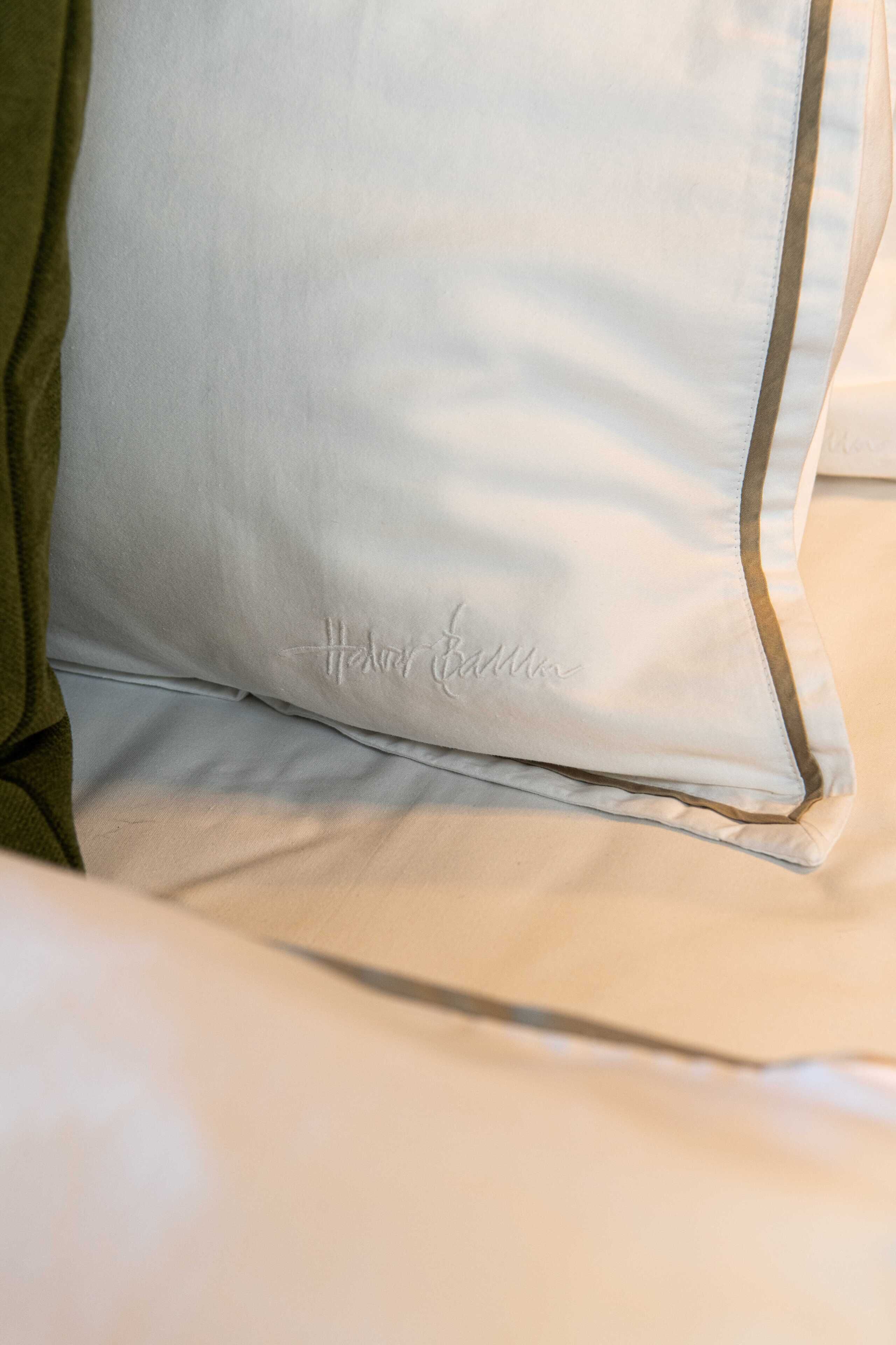 A pillow with a monogram and a green pillowcase.