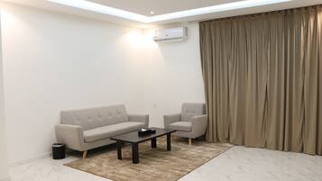 Appartamento Deluxe | Area soggiorno | TV a schermo piatto 65 pollici con canali satellitari, TV, caminetto