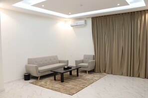 Leilighet – deluxe | Oppholdsområde | En 65-tommers Flatskjerm-TV med Parabol-TV samt TV og peis