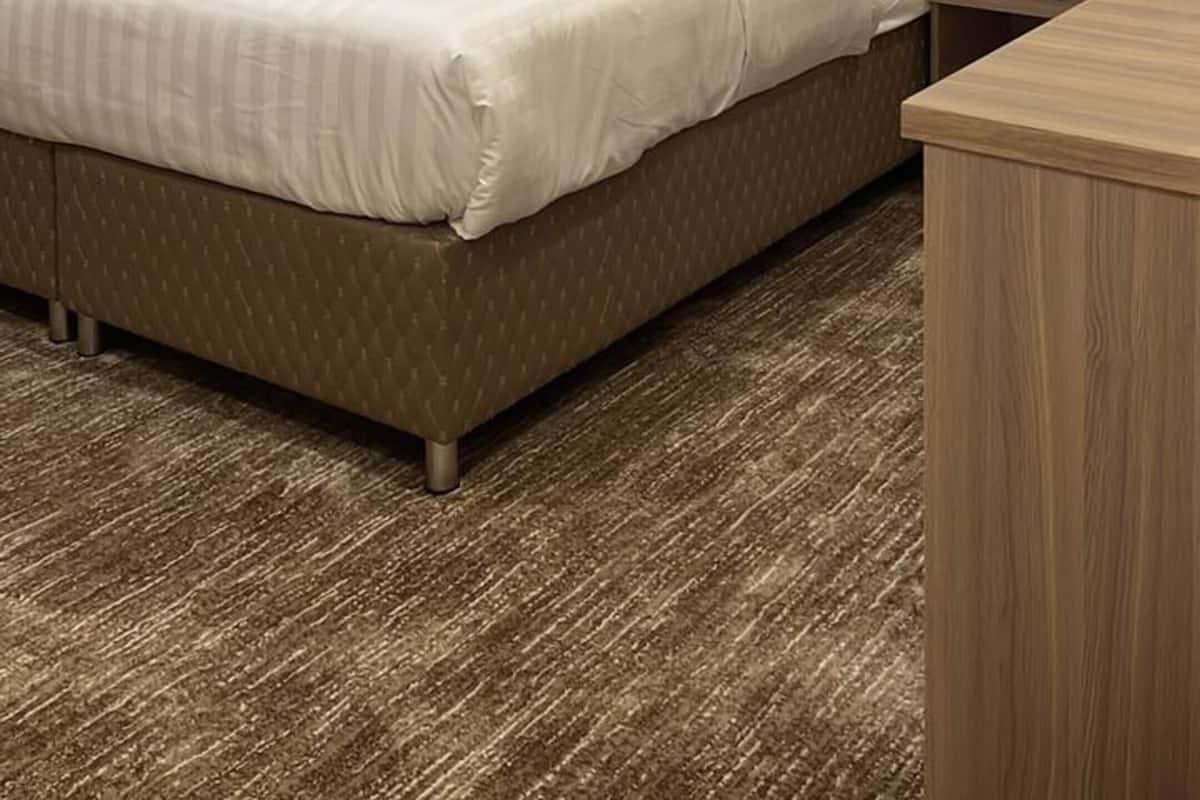 Une chambre d’hôtel moderne avec un grand lit, une table de chevet en bois et un bureau.