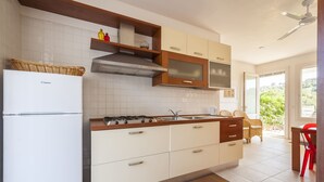 A modern kitchen with white cabinets, a built-in microwave, and a gas stove. - Casa Bellaria | RivedelSalento - Casa Bellaria piano terra (Castro)