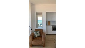 A modern living room with a brown sofa and a view of the beach through a large window. - Apartment by the sea with exceptional views (Soorts-Hossegor)