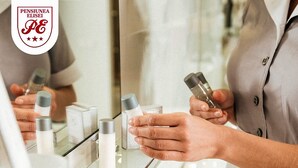 A person in a bathroom holding a bottle and a container, with toiletries on the counter. - PENSIUNEA ELISEI (Timisoara)