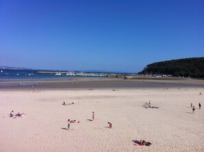 A wide sandy beach with people sunbathing and swimming. - Morgat, charming little house near the beach (Crozon)