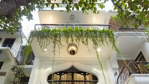 A hotel entrance with a sign reading "Camilia Executive Residence," featuring a grand archway, a black gate, and potted plants. - Camellia Residence Hanoi (Hanoi)