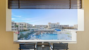 Un balcon donnant sur une piscine, avec une table et deux chaises.